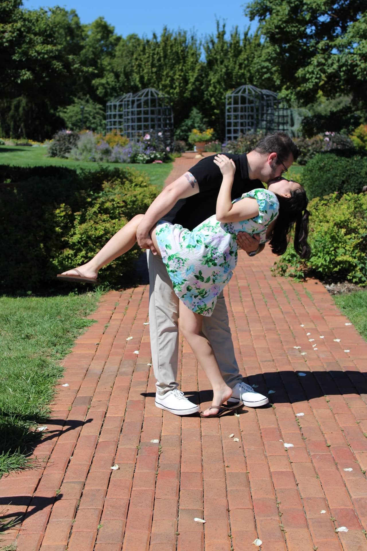 Couple sharing a dip and kiss on a garden brick path