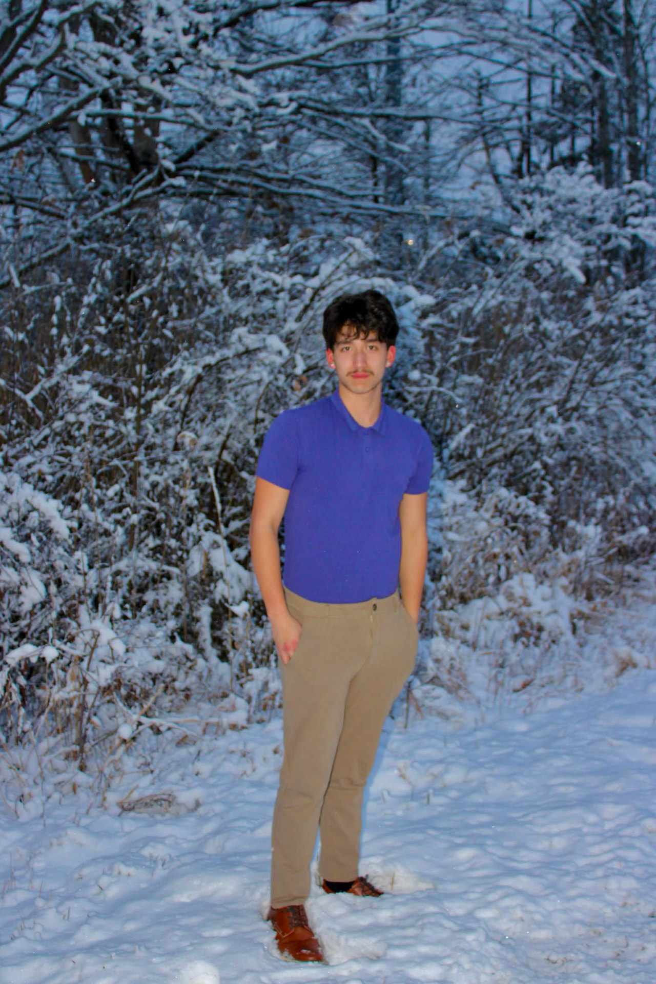 Senior portrait in a snow-covered treeline